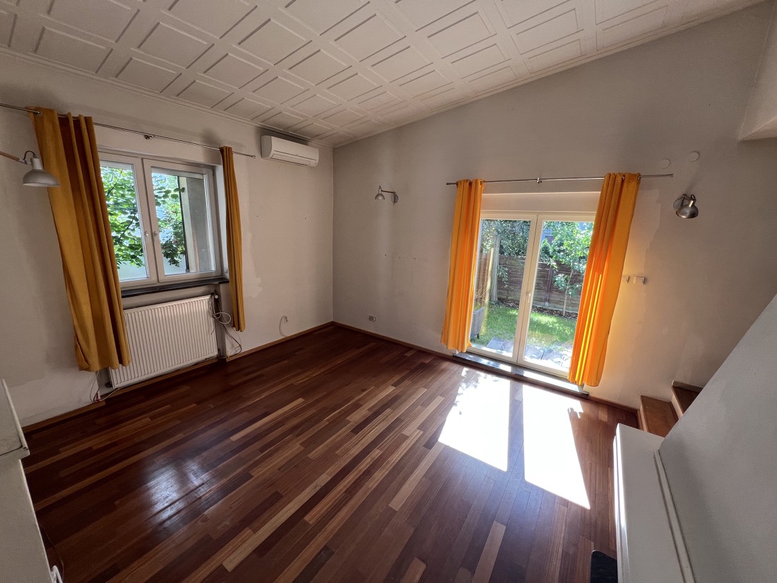 Jasny salon z drewnianą podłogą i dużymi oknami